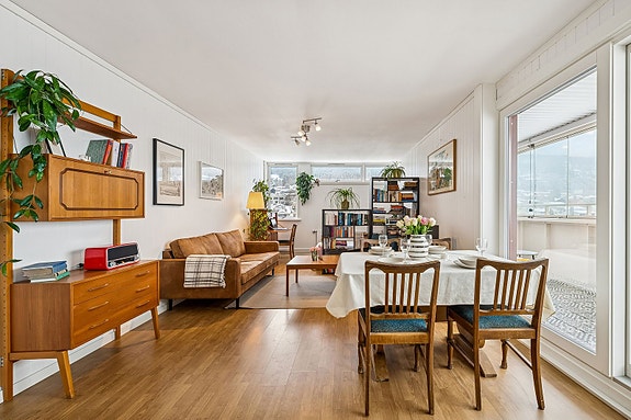 Lys og romslig stue med store vindusflater og behagelig takhøyde.