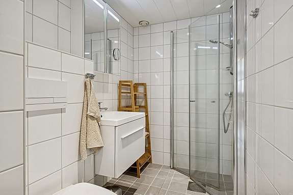 Oppgradert bad/vaskerom med flislagte overflater og gulvvarme.