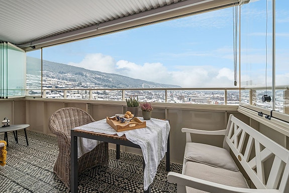 Romslig innglasset balkong med solrike formiddager og flott utsikt.