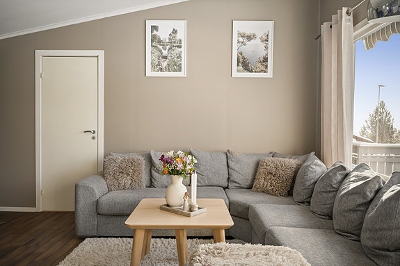 Romslig stue gir gode møbleringsmuligheter, inn døren finner en ett av boligens soverom.