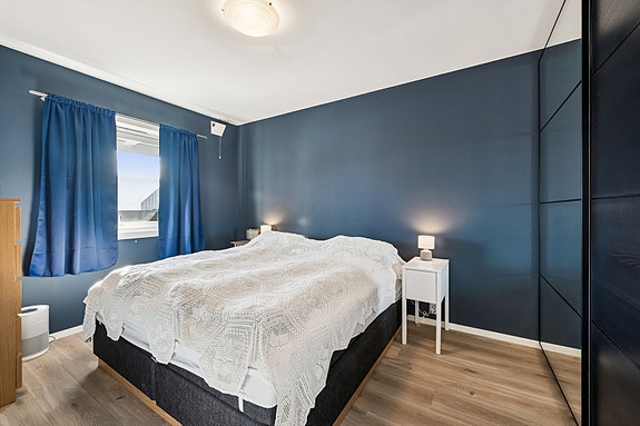 Hovedsoverommet er av god størrelse med plass til både dobbeltseng, nattbord og garderobeskap.