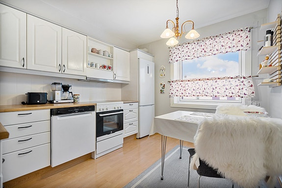 Romslig og praktisk kjøkken som har godt med benkeplass og oppbevaring samt plass for spisebord.