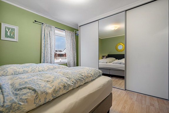 Soverom 1 inneholder en stor skyvedørsgarderobe som gir rikelig med oppbevaringsplass.