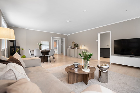En åpen stueløsning med rikelig naturlig lys og varme detaljer. Perfekt for både avslapning og hyggelige stunder med familie og venner