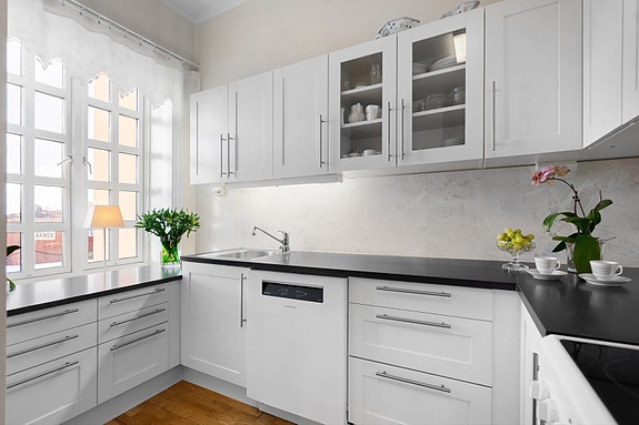Tidløst kjøkken med lyse fronter, rikelig med skapplass for oppbevaring og benkeplass