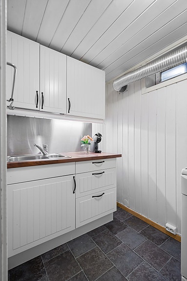 Kjøkkenet i underetasjen har innredning med profilerte fronter. Benkeplaten er av laminat.