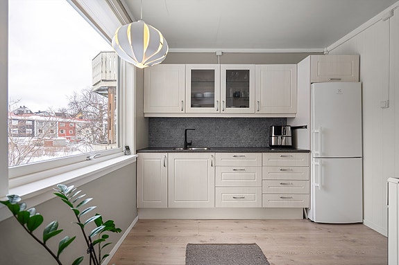 Kjøkken med lyse profilerte fronter og benkeplate av laminat.