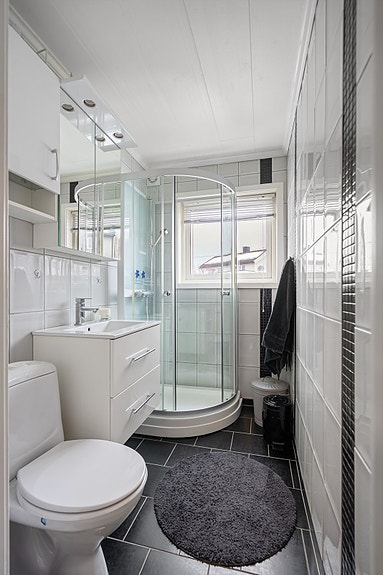 Flislagt bad med elektriske varmekabler i gulv. Rommet har innredning med nedfelt servant, toalett og dusjkabinett, samt mekanisk avtrekk.