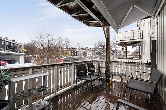 Overbygd balkong med plass for møblering og oppbevaring.