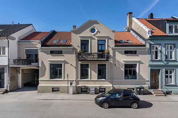 Ærverdig bygg med egen kjørport til parkering i bakgård.