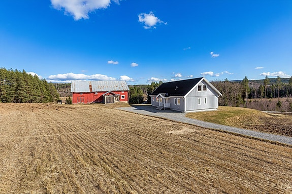 Velkommen til Homsjøvegen 171! Et nyere våningshus fra 2021 med en romslig låve, beliggende i landlige og fredelige omgivelser. Foto v/Bjørn Sørheim, EFKT