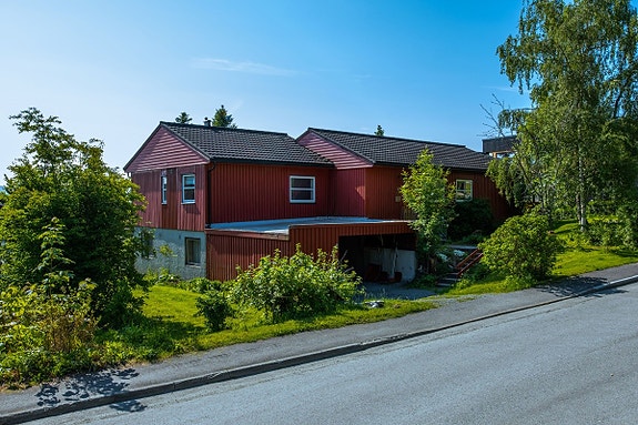 Huset sett fra gaten. Leiligheten er i sokkeletasjen. Leiligheten har parkeringen i Carport og inngang fra carport.