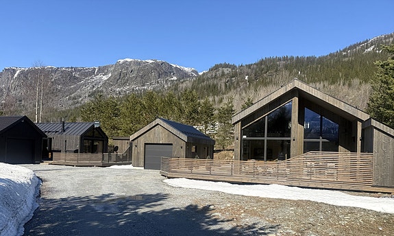 Innholdsrikt tun i moderne arkitektur med to boliger, to garasjer, romslige boder og solrike terrasser