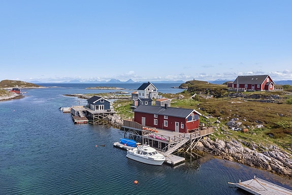 Autentisk rorbu - utsikt over sjø og fjell. Om sommeren yrer det av liv her ute i det gamle fiskeværet, ofte kalt bare "uti være". Da kommer "bueierne" ut til eiendommene sine og benytter ledig tid på feriering uti øyan. Foto: Lene Blomsøy ved Efkt.