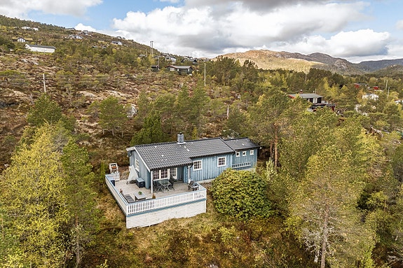 På en høytliggende og usjenert tomt finner du denne sjarmerende fritidsboligen i Nordåsen Hyttefelt. Hytten ligger vakkert til i naturlige omgivelser, skjermet av trær og vegetasjon, med en fantastisk utsikt utover fjorden.