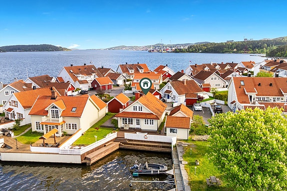 Vakkert i vannkanten med egen brygge, garasje, sjøbod og helhetlig fargeskala.