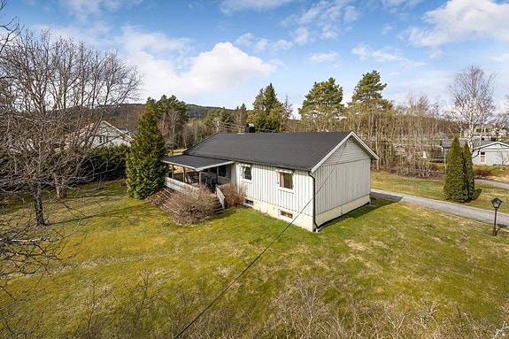 Velkommen til Vollafaret 4! En enebolig fra 1967 med en romslig og tilnærmet flat tomt, opparbeidet med gressplen og beplantning. Foto: Svein Michaelsen
