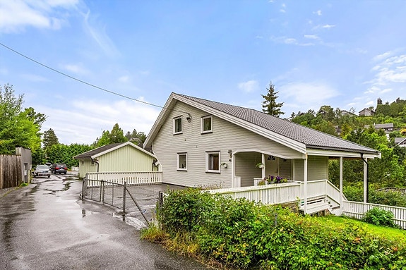 Innbydende fasade med overbygd inngang og god plass på egen gårdsplass.