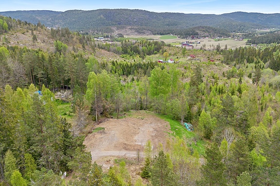 Tomten ligger høyt og fint til med vei til eiendommen.