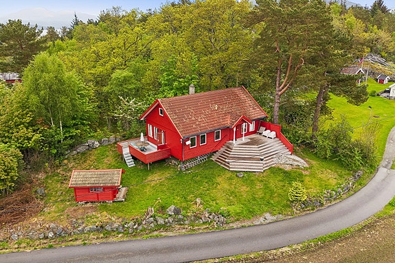 Fritidsbolig fra 1996 med to terrasser og en naturskjønn beliggenhet i lett skrånet terreng.