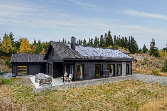 Hytta har solcellepanel på taket, som gir miljøvennlig og kostnadseffektiv energi.