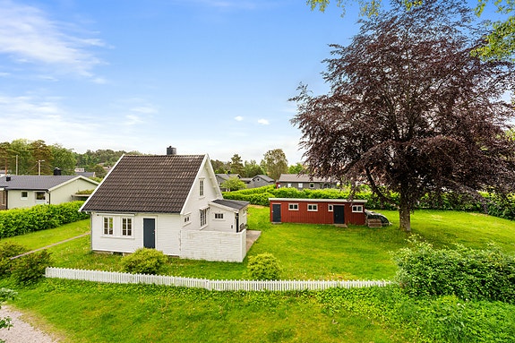 Enebolig med stor tomt på 1376m² - del av plen er utenfor denne tomten - illustrert med strek i bilde