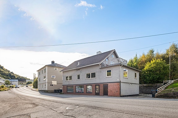 Næringsseksjon med butikklokale og lagerrom. Felles parkeringsplass. Tilhørende tomt bak huset.
