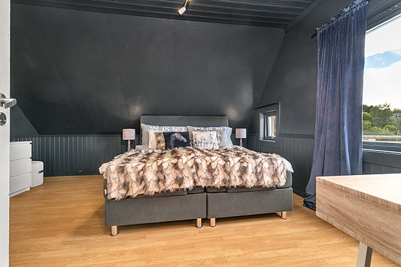 Loftsetasje - Soverom 1, romslig soverom med god plass for sengemøbler, oppbevaring og arbeidsplass.