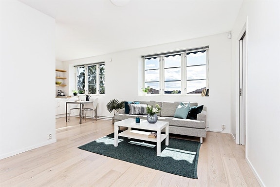 Leiligheten har åpen løsning mellom kjøkken og stue. Plass til både spise- og sofaseksjon.