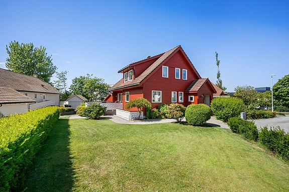 Eiendommen har en pent opparbeidet hage med plen og beplantning.