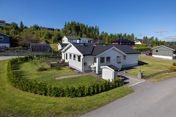 Velkommen til Roseveien 3! Foto: Norman Foto AS
Tomten er pent opparbeidet med plen og en tujahekk plantet i 2025.
