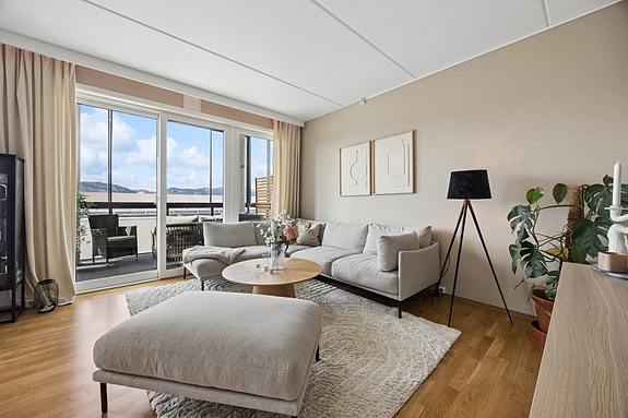 Stuen er lys og innbydende med moderne fargevalg og parkett på gulvet.