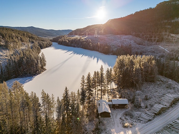 Eiendommen ligger fredelig til ved Nørdre Todalsvatnet, omgitt av skog og fjell. Foto: EIE og Terje Bjørnsen
