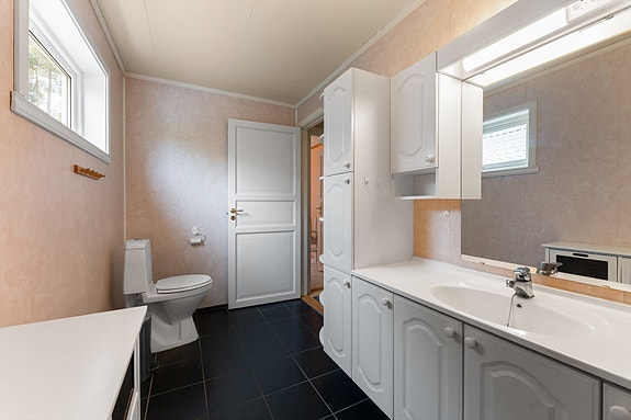 Romslig baderomsinnredning med gode oppbevaringsmuligheter og god plass til å holde badet ryddig og oversiktlig.