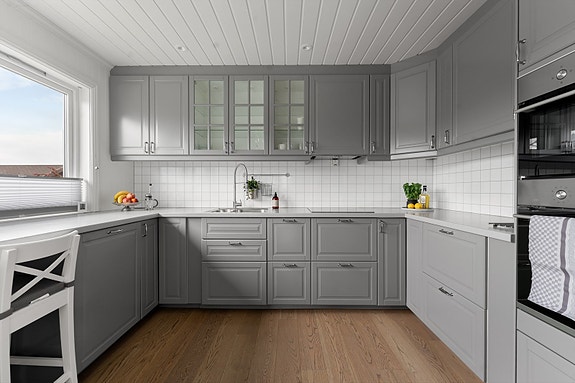 Stilrent kjøkken med rikelig med oppbevaringsplass og gode arbeidsflater - praktisk og innbydende for både hverdag og selskap.