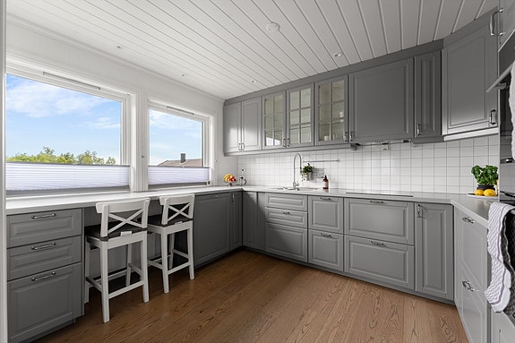 Praktisk og innholdsrikt kjøkken med profilerte fronter og laminatbenkeplate. Praktisk spiseplass for to ved kjøkkenbenken - perfekt for en rask frokost eller et hyggelig hverdagsmåltid.