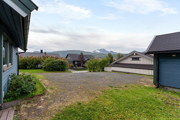 Gruset innkjørsel, gårdsplass, parkeringsplasser og gangveier. Pent opparbeidet adkomst til hovedinngangen, samt betongheller og platt ved inngangspartiet.