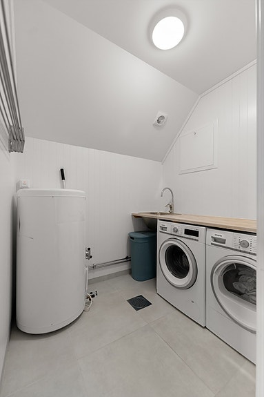 Vaskerom har flislagt gulv med elektriske varmekabler. Rommet har innredning med nedfelt servant og opplegg for vaskemaskin.