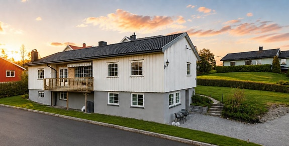 Velkommen til Elveveien 13 A! Bildet er tatt for noen år og det er i dag gårdsplass for naboen med asfalt foran oppkjørsel. Ca. 1 meter gressplen igjen ved siden av huset. To biloppstillingsplasser på tomten. Bildet er digitalt redigert