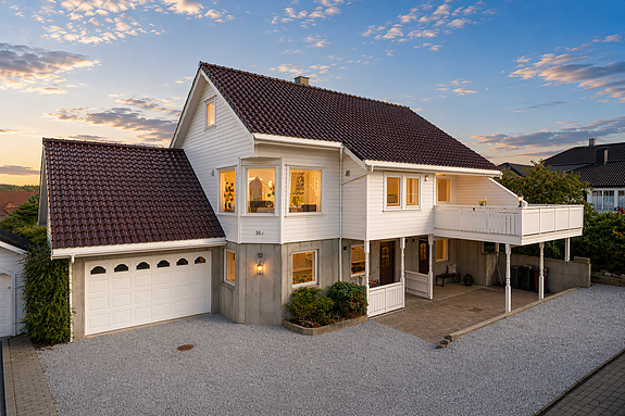 Stenebytoppen 16C: Stor og innholdsrik enebolig med hybeldel, glasserte takpanner, garasje og carport. Foto: Stian Dirdal. Kveldsstemning er AI-generert.