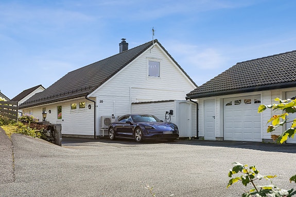 Flott enebolig med to garasjer og stor innkjørsel. Elbillader montert på utsiden av huset.