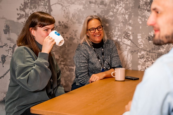 Tre kolleger tar kaffepause
