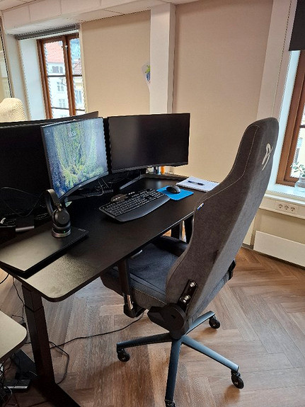 Hev og senk pult med gamingstol og doble skjermer. Behagelig arbeidplass