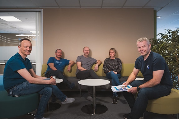 I pausene samles de gjerne rundt siste nummer av "Hakkstabben budstikke", en mangeårig internavis med egen redaktør og innspill/bilder fra de ansatte. Foto: Filmmark