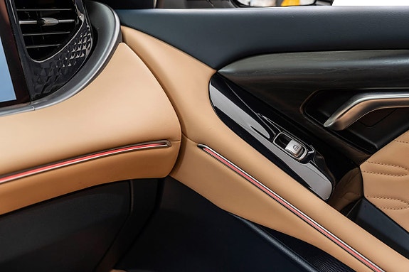 Beige skinninteriør med høy komfort og elegant midtkonsoll.