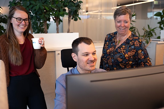 tre kolleger foran PC