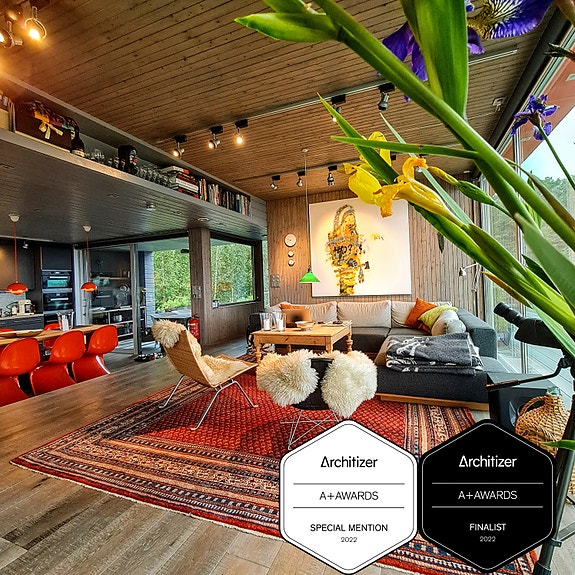 Varm og taktil materialitet som kontrasterer det stramme ytre. Store glassfelt gir åpenhet og visuell kontinuitet mellom interiør, uterom og landskap.