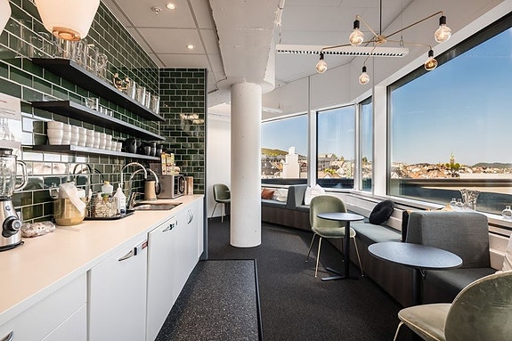 Kjøkkenområde utstyrt med kjøleskap, mikrobølgeovn og fryseboks