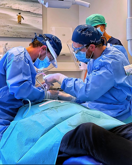 Tannlegene Misje og Amundgaard her under implantatkirurgisk inngrep.