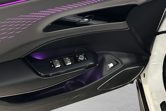 Dørpanel med moderne vinduskontroller og myk ambientbelysning.